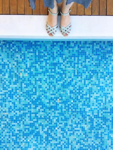 low-section-woman-standing-by-swimming-pool