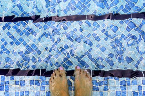 woman-feet-swimming-pool-water